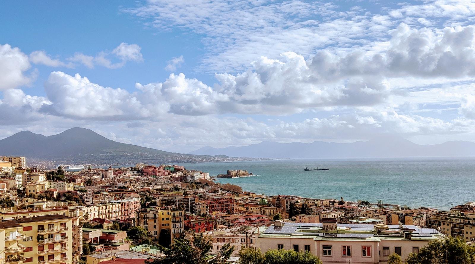 city buildings near sea under white clouds and blue sky during daytime