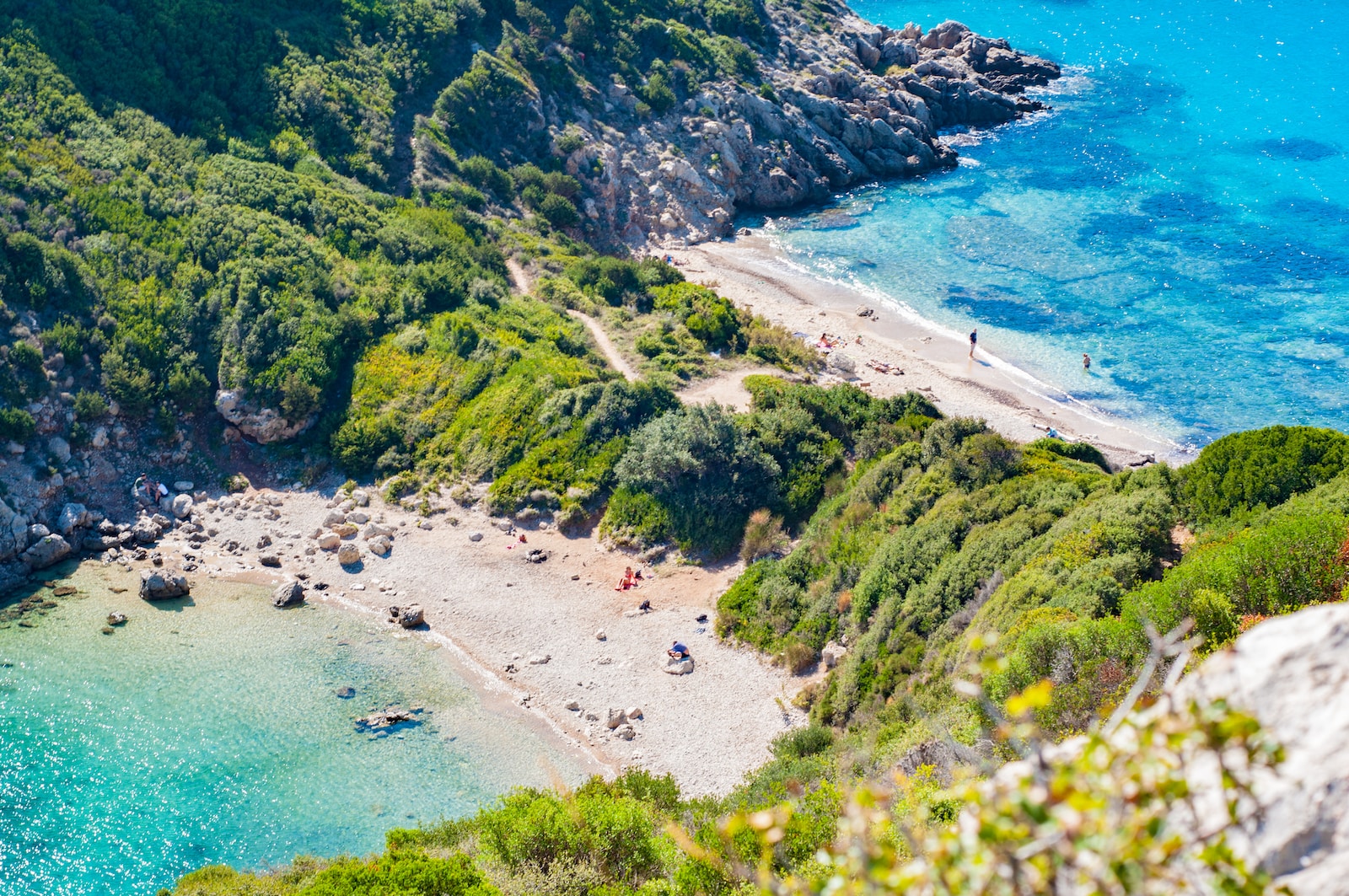 an aerial view of a sandy beach with blue water